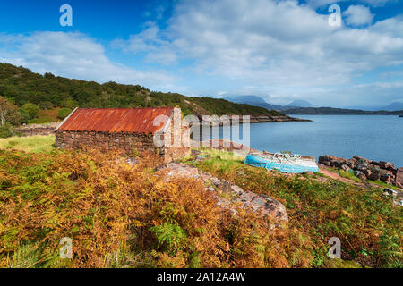 An old croft and a boat on the shores of Loch Torridon on the Applecross Peninsula in the Scottish Highlands Stock Photo