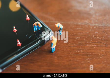 Miniature people Construction worker  repair smartphone using as background Maintenance concept and repair concept with copy space for your text or de Stock Photo
