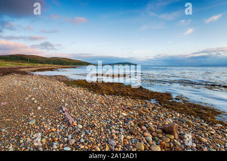 Dusk over the pebble beach at Machrie Bay on the Isle of Arran in Scotland Stock Photo