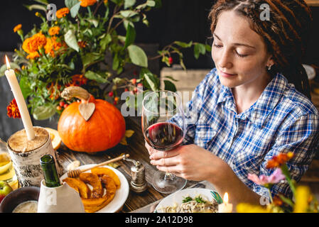 Holiday weekend cute dinner with red wine and pasta. Autumn set and yellow flowers on a wooden table in a rustic style. Concept romantic relationship Stock Photo