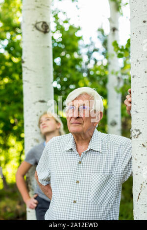 senior grandfather with his teen granddaughter in aspen forest Stock Photo
