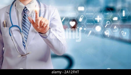 woman doctor holding hand and touching visual screen with hospital background Stock Photo
