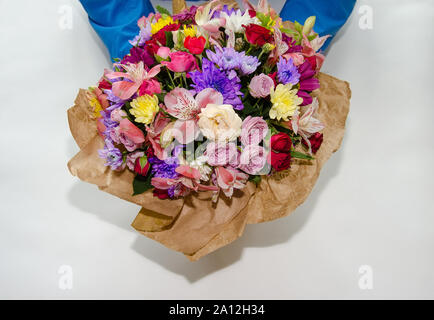 beautiful bouquet with different flowers of roses and chrysanthemums in the hands of a man. Colorful bouquet of different fresh flowers, close-up Stock Photo