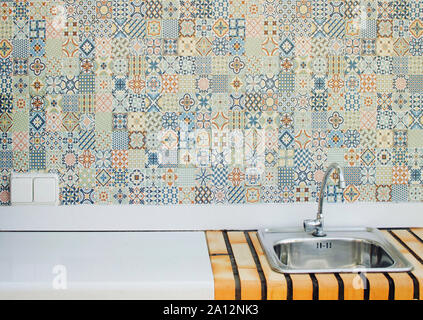 Water tap in an outdoor kitchen with patchwork tiles in the background, Chiclana de la Frontera, Cadiz, Spain Stock Photo
