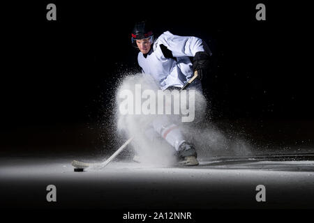 Ice hockey player in action kicking with stick Stock Photo