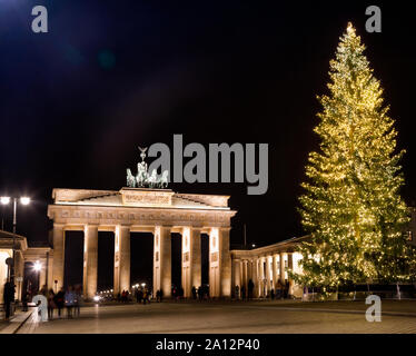 Illuminated Neoclassical Brandenburg Gate (Brandenburger Tor) and Christmas Tree as viewed from the Pariser Platz, Mitte, Berlin, Germany Stock Photo