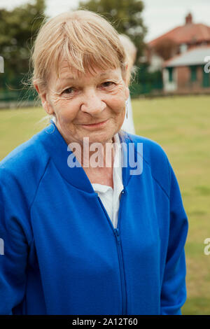 A portrait of a senior woman smiling at a bowling green. Stock Photo