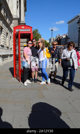 London, England UK. Three friends posing for a selfie by a traditional red telephone box in Whitehall Stock Photo