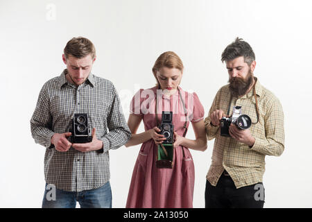 Vintage dressed company of photographers with old camera. Fashion Photographer with old film camera in hand while working in studio Stock Photo