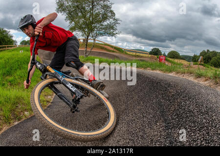 A man rides a mountain bike on a tarmac pump track at Mountain View Bikepark north of Cardiff, Wales. Stock Photo