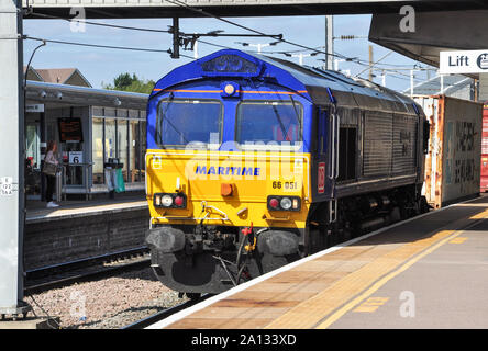 Maritime blue liveried class 66 diesel locomotive hauls a container freight south through Peterborough, Cambridgeshire, England, UK Stock Photo