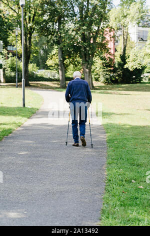 Older man walking with canes in the park Stock Photo