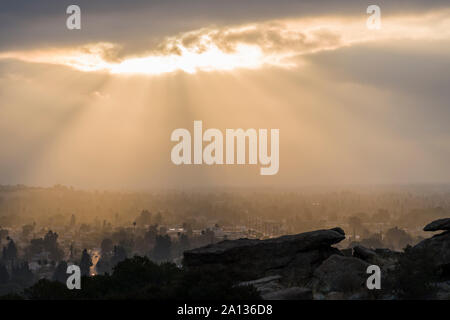 Sun bursting through low clouds near Chatsworth Park South in the San Fernando Valley area of Los Angeles, California. Stock Photo