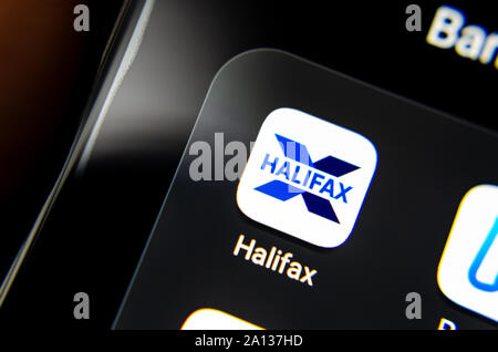 Halifax bank app seen on the edge of on the smartphone screen along with other banking apps. Close up photo with selective focus. Stock Photo