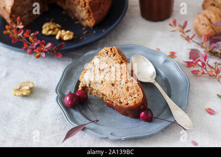 Apple pie with nuts, decorated with salted caramel and small red apples. Rustic style. Stock Photo