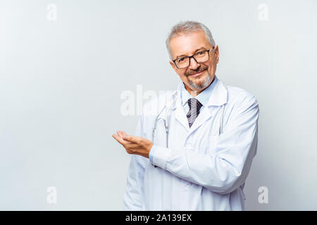 Cheerful mature doctor posing and smiling at camera, healthcare and medicine. Stock Photo