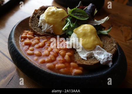 Healthy style English breakfast with poached eggs on brown toast on rustic wood background Stock Photo