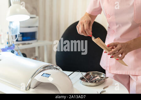 Packing manicure tools kraft paper bag for for further sterilization. Beauty salon. Cleanliness and disinfection. Stock Photo
