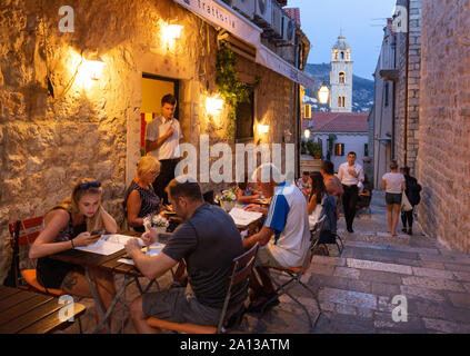 Dubrovnik holiday - tourists and locals eating at a restaurant outdoors in the evening, Dubrovnik old town, Dubrovnik Croatia Europe Stock Photo
