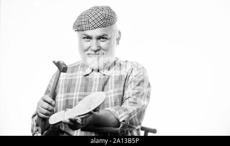 Fits perfect. shoemaker at work. mature shoemaker in workshop make shoes. Cobbler workmanship. shoemaker working with leather textile and hammer at workshop. retro man repair shoes with hammer. Stock Photo