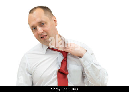 portrait of tired businessman taking off his tie. Isolated on white. man in shirt taking off his red necktie while standing against white background. Stock Photo