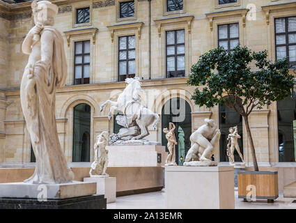 FRANCE, PARIS - MAY 16, 2016: A large hall with a glass roof and a large number of sculptures, including horses Marly in the Louvre. Paris. France. Stock Photo