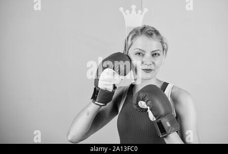 Feminine tender blonde with queen crown wear boxing gloves. Fight for success. VIP gym. Fighting queen. Woman boxing glove and crown symbol of princess. Queen of sport. Become best in boxing sport. Stock Photo