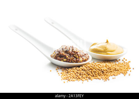 Yellow mustard and whole grain mustard in ceramic spoon with mustard seeds isolated on white background. Stock Photo