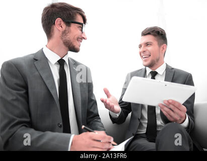 two men chatting while sitting in the office Stock Photo