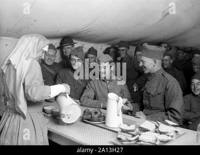 A French infantryman surrounded by Americans in an American red cross canteen. Stock Photo