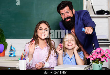 Teaching daughter. Mom and dad teachers helping child with learning. Good learning environment. Learners must feel supported welcomed and respected. Smart family. Favorable conditions for learning. Stock Photo