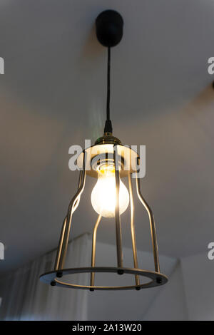 Metal Chandelier loft style with light bulbs hanging from the ceiling. Stock Photo