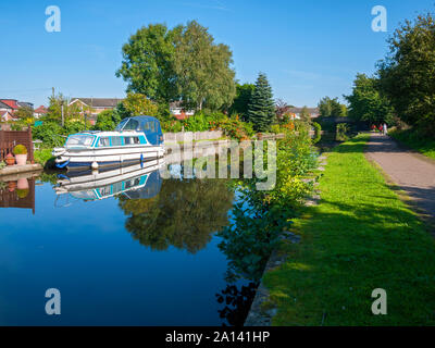 A narrowboat and trees reflected in the Ashton Canal at Droylsden, Tameside, Manchester, UK Stock Photo
