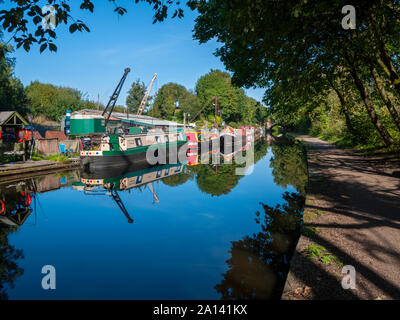 Narrowboats at a boat repair yard reflected in the Ashton Canal, at Ashton-under-Lyne, Tameside, Manchester, UK Stock Photo