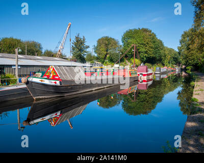 Narrowboats at a boat repair yard reflected in the Ashton Canal, at Ashton-under-Lyne, Tameside, Manchester, UK Stock Photo