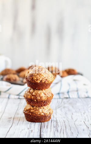 Beautiful fresh baked homemade pumpkin muffins stack on top of each other against a white background. Selective focus on bread in front with blurred b Stock Photo