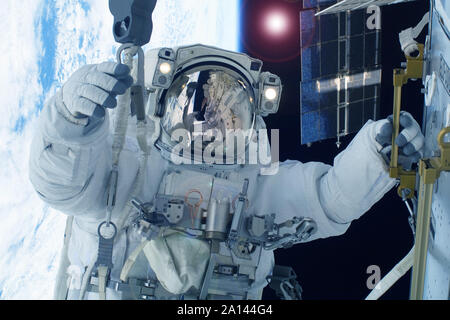 Astronaut in space against the background of the earth. Elements of this image were furnished by NASA Stock Photo