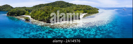 Aerial view of beautiful corals fringing a limestone island in Raja Ampat, Indonesia. Stock Photo