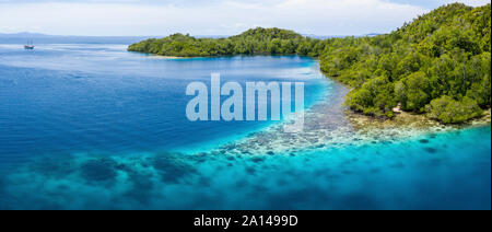 Aerial view of beautiful corals fringing a limestone island in Raja Ampat, Indonesia. Stock Photo