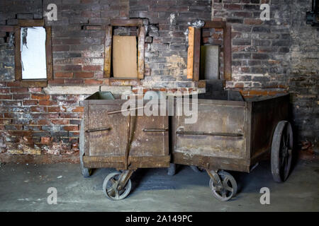 Old metal carts stand in a spooky decaying warehouse Stock Photo