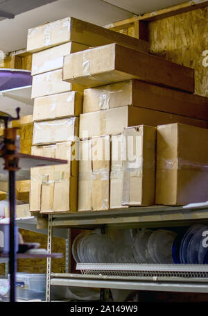 stacks of mysterious boxes are arranged on a metal shelf in n old closet Stock Photo