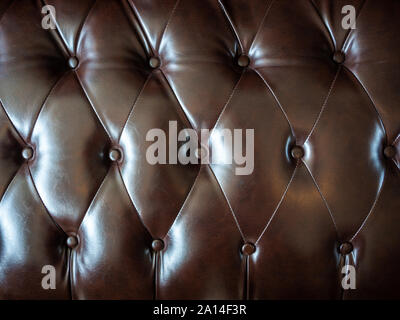 Close-up vintage brown leather button sofa texture. Pattern leather sofa background. Stock Photo