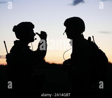 Two U.S. Air Force Survival, Evasion, Resistance and Escape specialist assigned to the 352nd Special Operations Wing, discuss risk factors during a casualty evacuation training in Estonia. The training was part of a larger exercise to conduct a multitude of air operations with other U.S. and Estonian Special Operations Forces, out of Air Force Special Operations Command’s CV-22 Osprey. (U.S. Army photo by Staff Sgt. Elizabeth Pena) Stock Photo