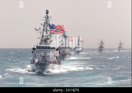 The Cyclone-class coastal patrol ship USS Hurricane leads other ships in formation. Stock Photo