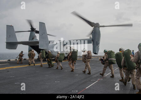 Marines board an MV-22 Osprey on the flight deck of USS Kearsarge. Stock Photo