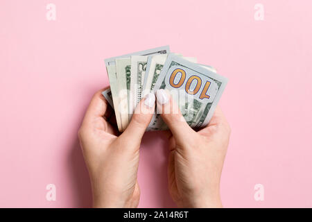 Top view of female hand holding a pack of money on colorful background. Various dollars. Business concept. Charity and tips concept. Stock Photo