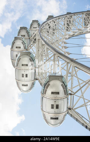 Closeup of slow-moving cars on the famous London Eye ride and tourist attraction. Taken directly under capsules looking skyward, inspires vertigo. Stock Photo