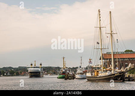 the ferry from Aero arriving at the port of Svendborg with many old ships, Denmark, July 13, 2019 Stock Photo