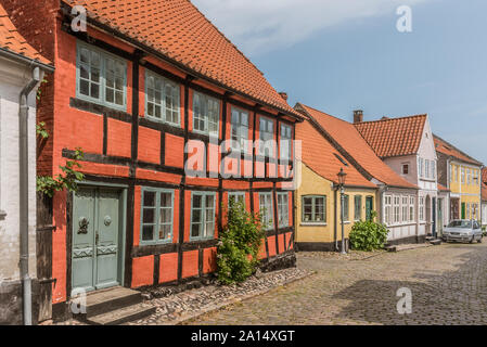 the facade of a red two stock half-timbered house in a cobbled street, island of Aero, Denmark, July 13, 2019 Stock Photo