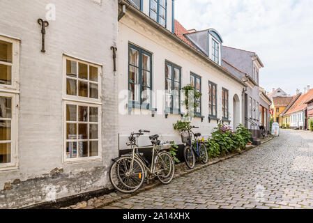 bikes on the pavement along the walls of stone houses on a cobblestone- lane, The island of Aero, Denmark, July 13, 2019 Stock Photo
